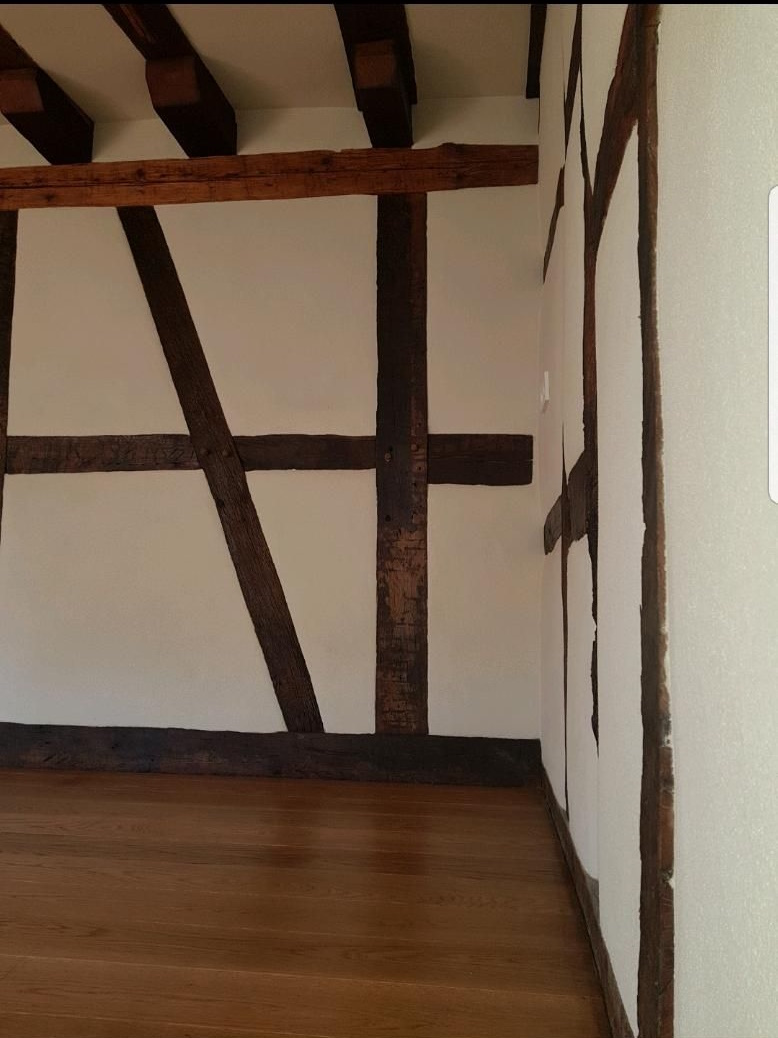 Fertig restauriertes Zimmer im Fachwerkhaus mit Lehmputz und freigelegten Balken